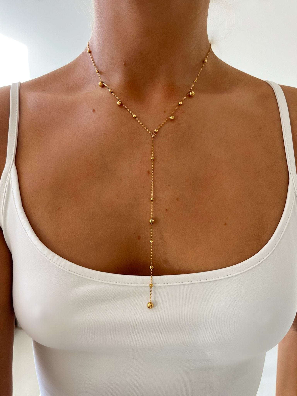 Women's gold-colored Y necklace in stainless steel with a pearl chain and long teardrop design – elegant jewelry for everyday wear, parties, and evening styling