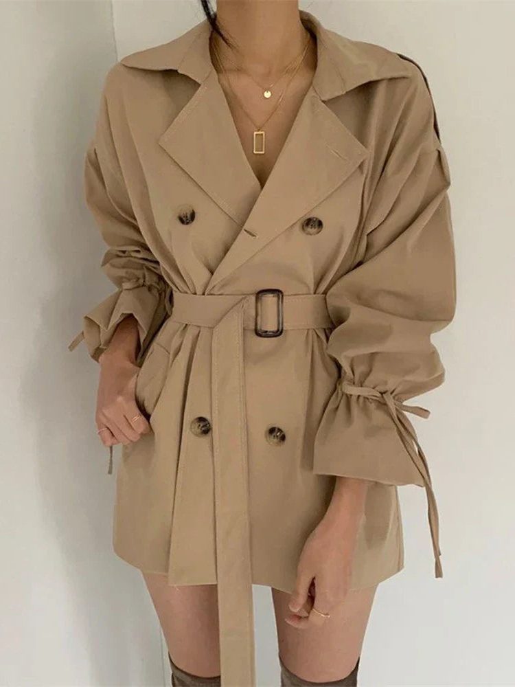 Dámský oversized trenčkot s dvouřadým zapínáním, páskem, širokými klopami a zavazovacími detaily na manžetách – elegantní přechodový kabát pro každodenní nošení a stylové vrstvení